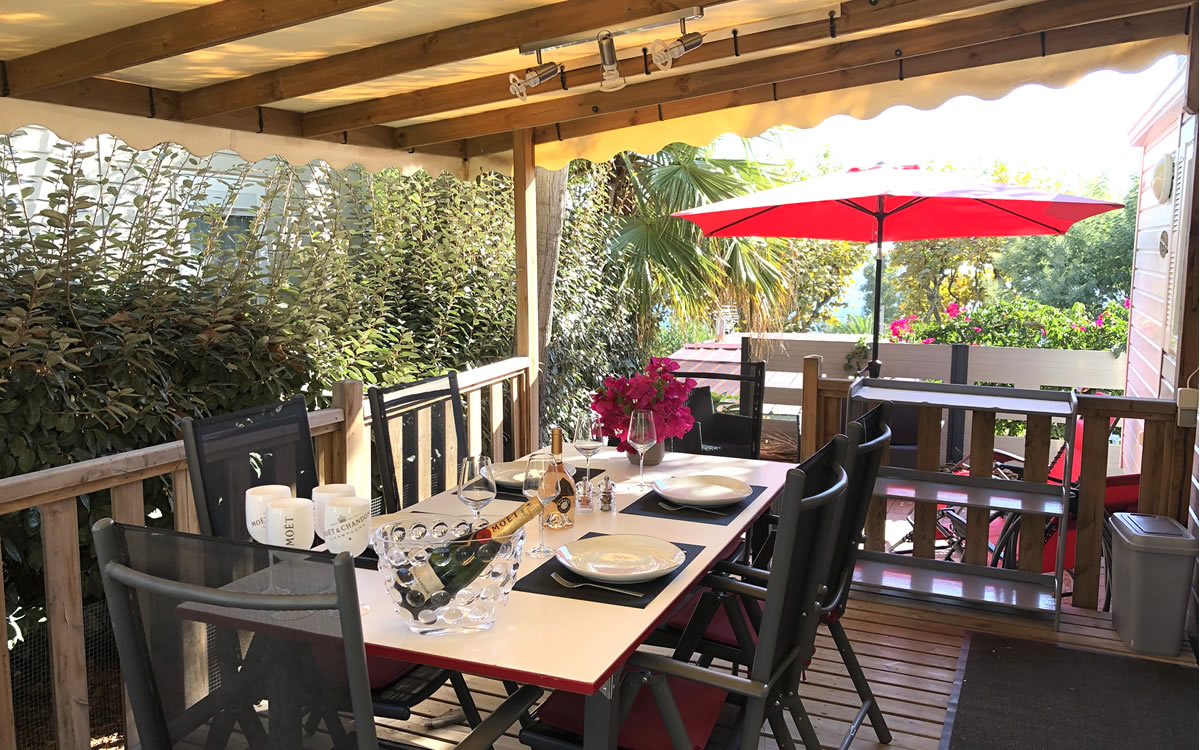 Vue de la terrasse privée sous la tonelle du mobilhome Saint-Raphaël. Il est très agréable d'y prendre les repas.